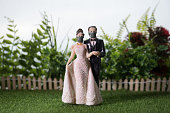 Miniature people : Happy bride wearing masks to protect against viruses during wedding time. People wear masks to prevent New type COVID-19 pneumonia. Coronavirus and Covid-19 concept. Selective focus