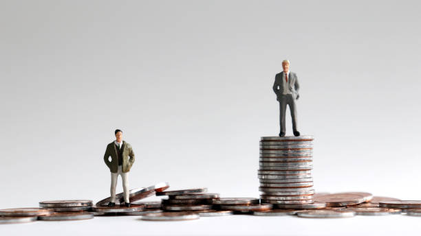 Miniature people standing on a pile of coins. Miniature people standing on a pile of coins. poverty stock pictures, royalty-free photos & images