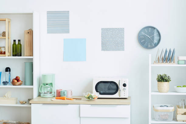 Minimal Kitchen Interior Background image of contemporary kitchen interior in pastel colors with focus on microwave oven and analog clock, copy space college dorm stock pictures, royalty-free photos & images