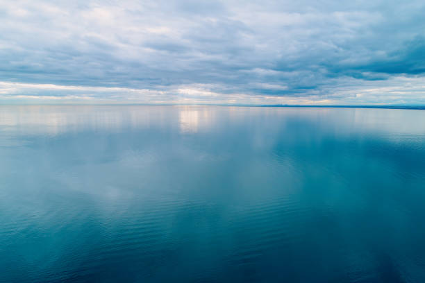 Minimalist aerial seascape. Overcast sky over calm and smooth water surface Minimalist aerial seascape. Overcast sky over calm and smooth water surface horizon over water stock pictures, royalty-free photos & images