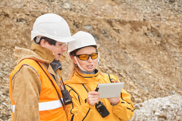 mining engineers discussing working documentation at the mining site mining engineers discussing working documentation outdoor at the mining site geologist stock pictures, royalty-free photos & images