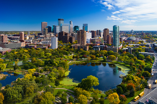 Minneapolis aerial with Downtown Minneapolis skyline in the background and Loring Park with Loring Pond in the foreground, during early autumn.