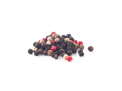 Mix of black, white, green and pink peppercorns isolated on white background