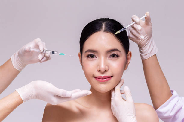 Mixed Asian young 20s woman going through skin care and aesthetic medical therapy and to be injected by hands of doctor with syringes in white background. Mixed Asian young 20s woman going through skin care and aesthetic medical therapy and to be injected by hands of doctor with syringes in white background korean culture photos stock pictures, royalty-free photos & images