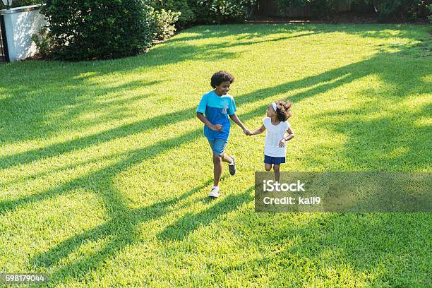 Mixed race brother and sister playing in park