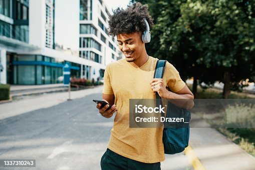 istock Mixed race millennial man in downtown, using mobile phone 1337310243