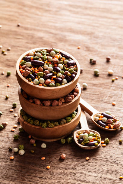 Mixed raw dried Indian legumes in wooden bowls on rustic background. stock photo