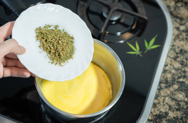 Mixing crushed cannabis with melted butter to prepare marijuana butter or cannabutter, a cannabis edible. Mixing crushed cannabis with melted butter to prepare marijuana butter cannabutter stock pictures, royalty-free photos & images