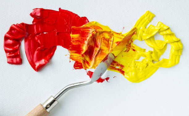 mixing red and yellow oil paints - misturar imagens e fotografias de stock