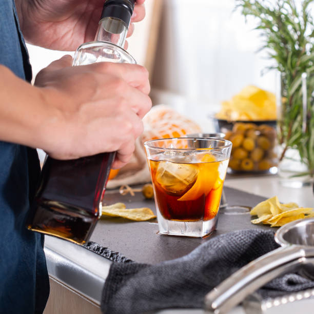 Mixologist making refreshing cocktail with vermouth at home stock photo