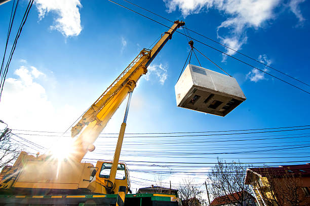 Mobile crane operating by lifting and moving electric generator stock photo