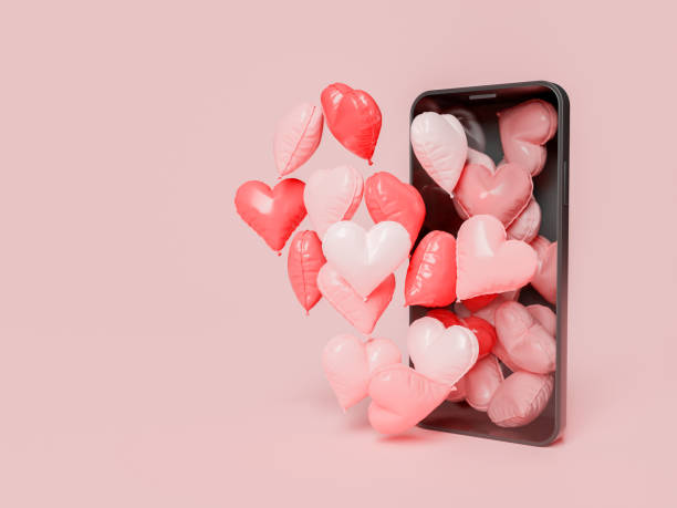 mobile phone with many heart balloons coming out of the screen stock photo