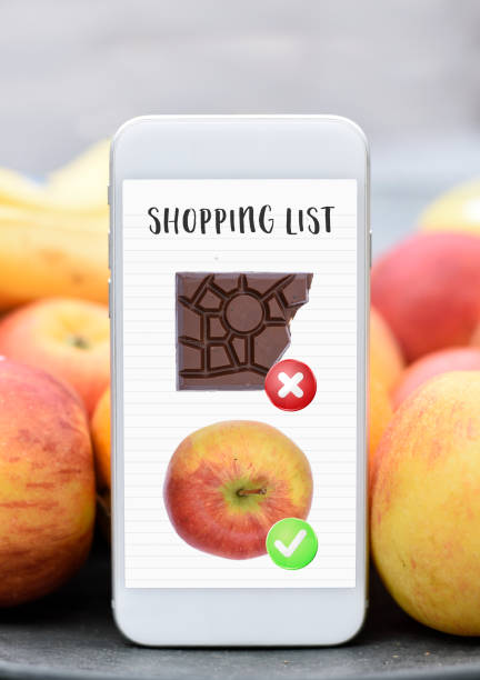 Mobile phone with shopping list healthy vs unhealthy no chocolate eat an apple dieting stock photo