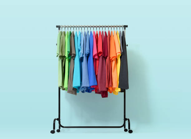 mobile rack with color clothes on light blue background - clothes wardrobe imagens e fotografias de stock