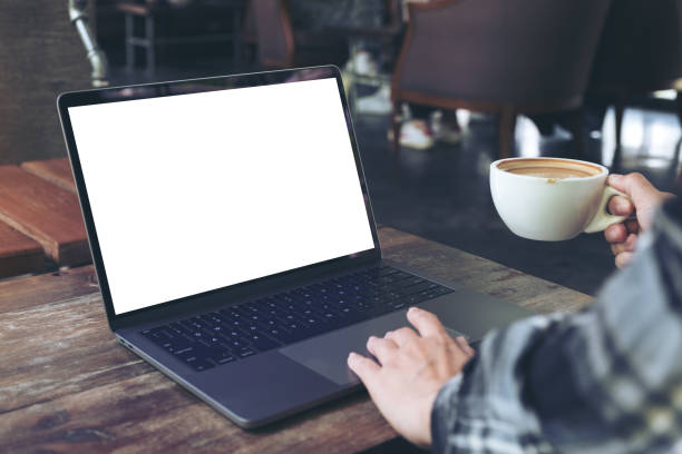 gambar mockup seorang wanita menggunakan laptop dengan layar desktop putih kosong sambil minum kopi panas di kafe - fotografi citra potret stok, foto, & gambar bebas royalti