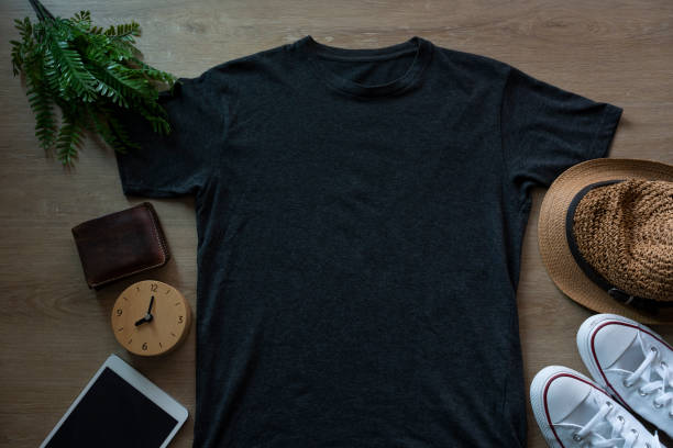 Mockup of a black t-shirt blank shirt template with accessories on the wooden table background, lifestyle and travel concept stock photo