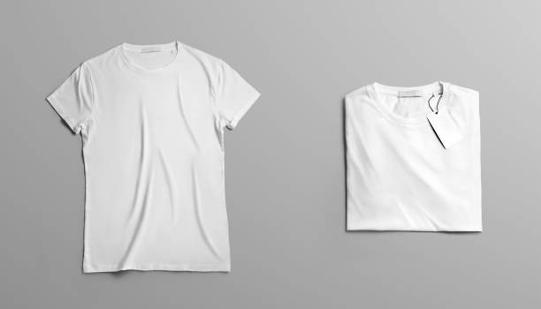 Mockup of two blank t-shirt on a gray studio background. Mockup  clothes The first open blank T-shirt lies on grey studio background. Second  t-shirt  with label neatly folded on a background. Top view template for fashion design. shirt stock pictures, royalty-free photos & images