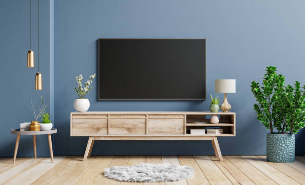Mockup television on cabinet in contemporary empty room with dark blue wall behind it. Mockup television on cabinet in contemporary empty room with dark blue wall behind it.3D rendering camisetas futbol stock pictures, royalty-free photos & images