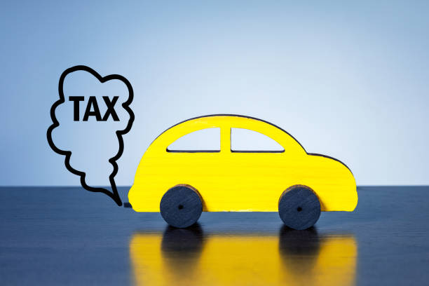 Model car and word TAX in smoke on blue background. Car pollution tax concept. stock photo