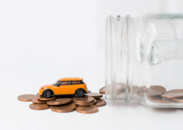 A model car is on coins. Rising costs for gasoline car prices, insurance and taxes. A model car is on coins. Rising costs for gasoline car prices, insurance and taxes. allowance stock pictures, royalty-free photos & images