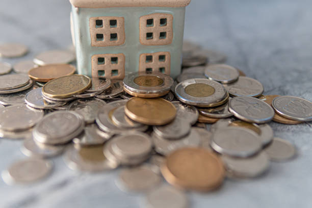 Model House with stack of coins - House financing mortgage concept stock photo