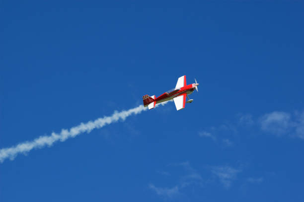 Model of acrobatic airplane flying in a blue sky stock photo