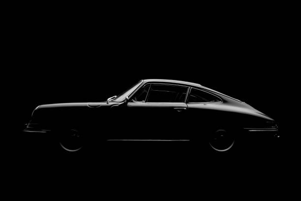 Model Porsche 911 In Black And White Beaconsfield, UK - November 28, 2016: A 1:18 scale model of a 1964 Porsche 911, set against a solid black background. Low key/black & white image. porsche 911 stock pictures, royalty-free photos & images