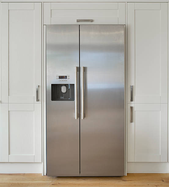 modern American fridge freezer "a modern American fridge freezer set into a bank of cream coloured cupboards in a farmhouse-style kitchen. Made from brushed stainless steel, this is a high quality unit with ice cube dispenser.Looking for a Kitchen, Dining Room or dining related image Then please see my other images by clicking on the Lightbox link below..." appliance photos stock pictures, royalty-free photos & images