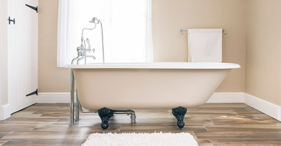 Modern bathroom interior design with clawfoot bath tub and floor tiles. Luxury, contemporary bathrooms, UK.