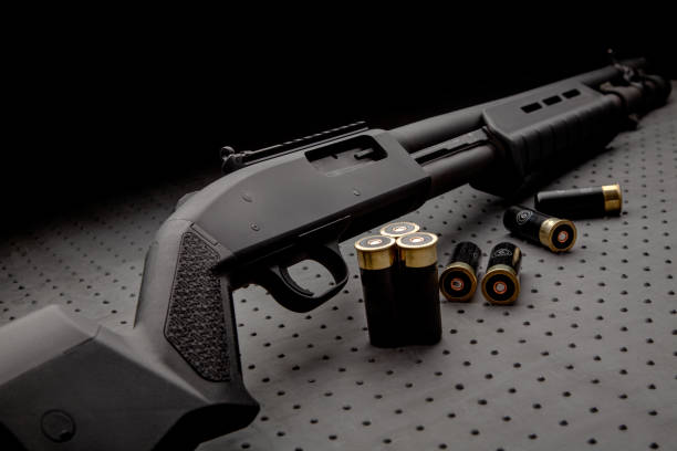 Modern black shotgun and ammo for him on a dark background. stock photo