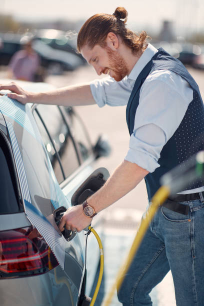 Modern busnessman charging his electric car stock photo