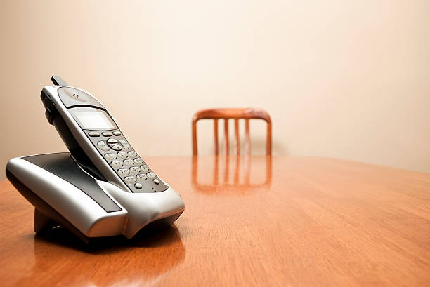 Modern cordless phone sitting on a table stock photo