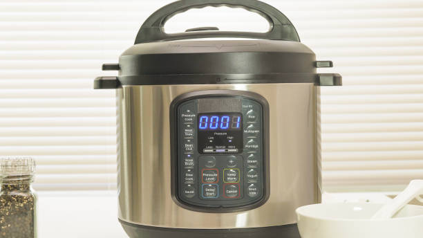Modern electric multi cooker close up on kitchen table. Up to 1 minutes cooking time remaining stock photo