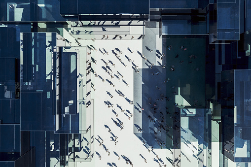 Modern glass office building with business people from above. 3D generated image.