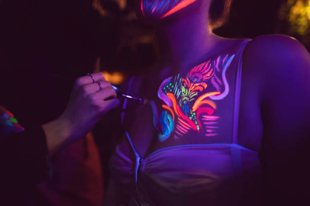 Modern Glow Close-up shot of a body painting process. paint neon color neon light ultraviolet light stock pictures, royalty-free photos & images