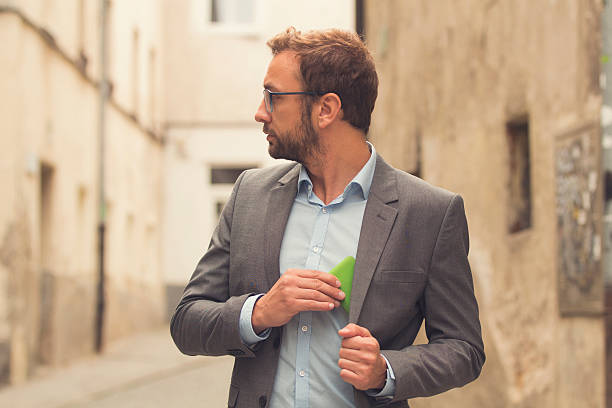 Modern guy using cellphone outdoors. stock photo