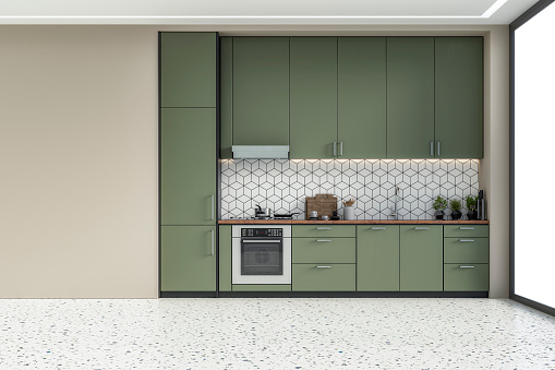 Empty modern kitchen with khaki green high wooden kitchen cabinets with tiled pattern background and ceiling led lights. A large beige plaster wall background on terrazzo floor with copy space and windows on a side. Retro style of 70's. 3D rendered image.