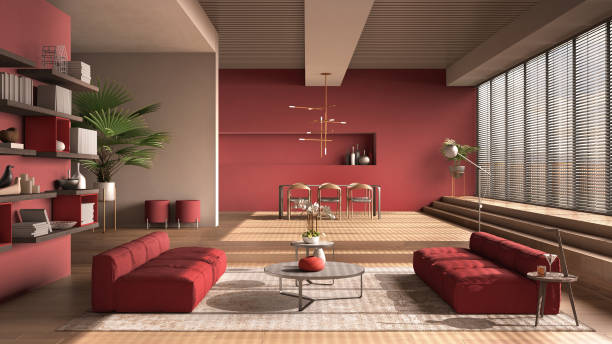 Modern living room in red tones, hall, open space with parquet oak floor with steps, sofa, carpet and coffee tables, dining table with chairs and lamps, minimal interior design stock photo