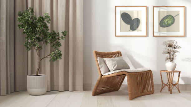 Modern living room in white tones. Close up. Rattan armchair with pillows, curtains, pictures and potted plant. Parquet floor and plaster walls. Retro interior design stock photo