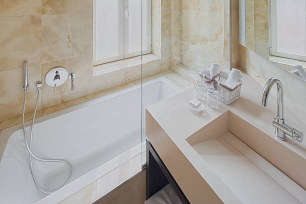 Modern luxury hotel bathroom interior with plexiglass bahroom enclosures