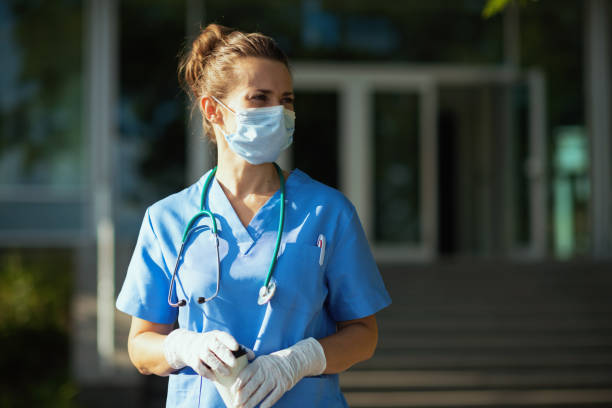 modern physician woman in uniform outdoors near clinic stock photo