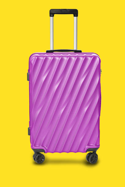 Modern purple suitcases bag isolated on yellow background with clipping path on luggage object stock photo