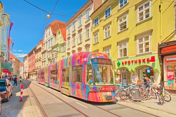 A modern tram with colorful advertisements is going along one of the central streets of Graz stock photo