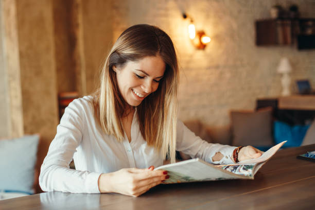 Modern woman reading magazine in cafe stock photo
