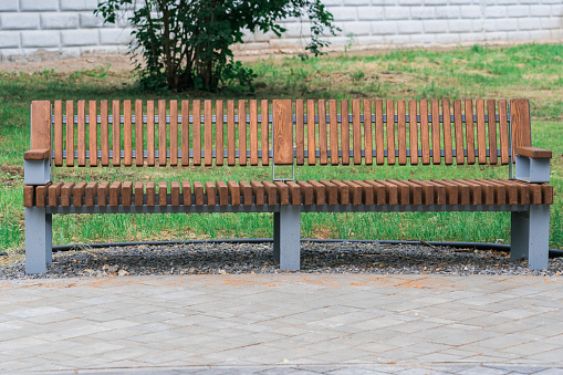 Modern wooden bench in the city park