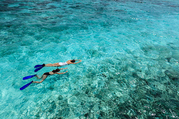 Mom &amp; daughter: Snorkling during vacation Mother and daughter during their vacation in the Maldives. Turquoise water - crystal clear - great to see fishes and the reef snorkeling stock pictures, royalty-free photos & images