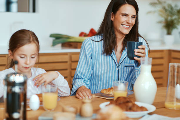 Mom and daughter having breakfast stock photo