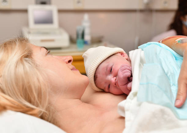 Mom and newborn baby skin to the skin after birth in the hospital Mom and newborn baby skin to the skin after birth newborn stock pictures, royalty-free photos & images