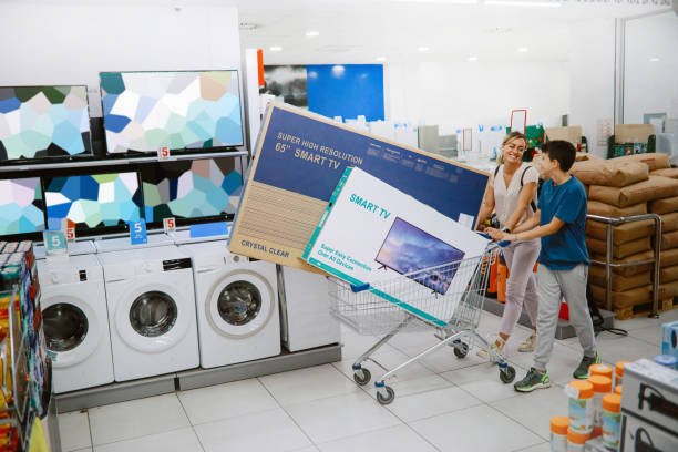 Mom and son buying large TV sets in the shopping mall stock photo