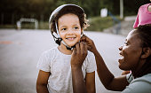 istock Mom helping little girl with protective helmet 1168485430